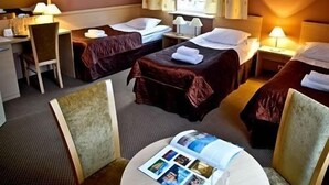 A hotel room with two beds, a desk, and a chair. - Hotel Carskie Koszary (Zamosc)