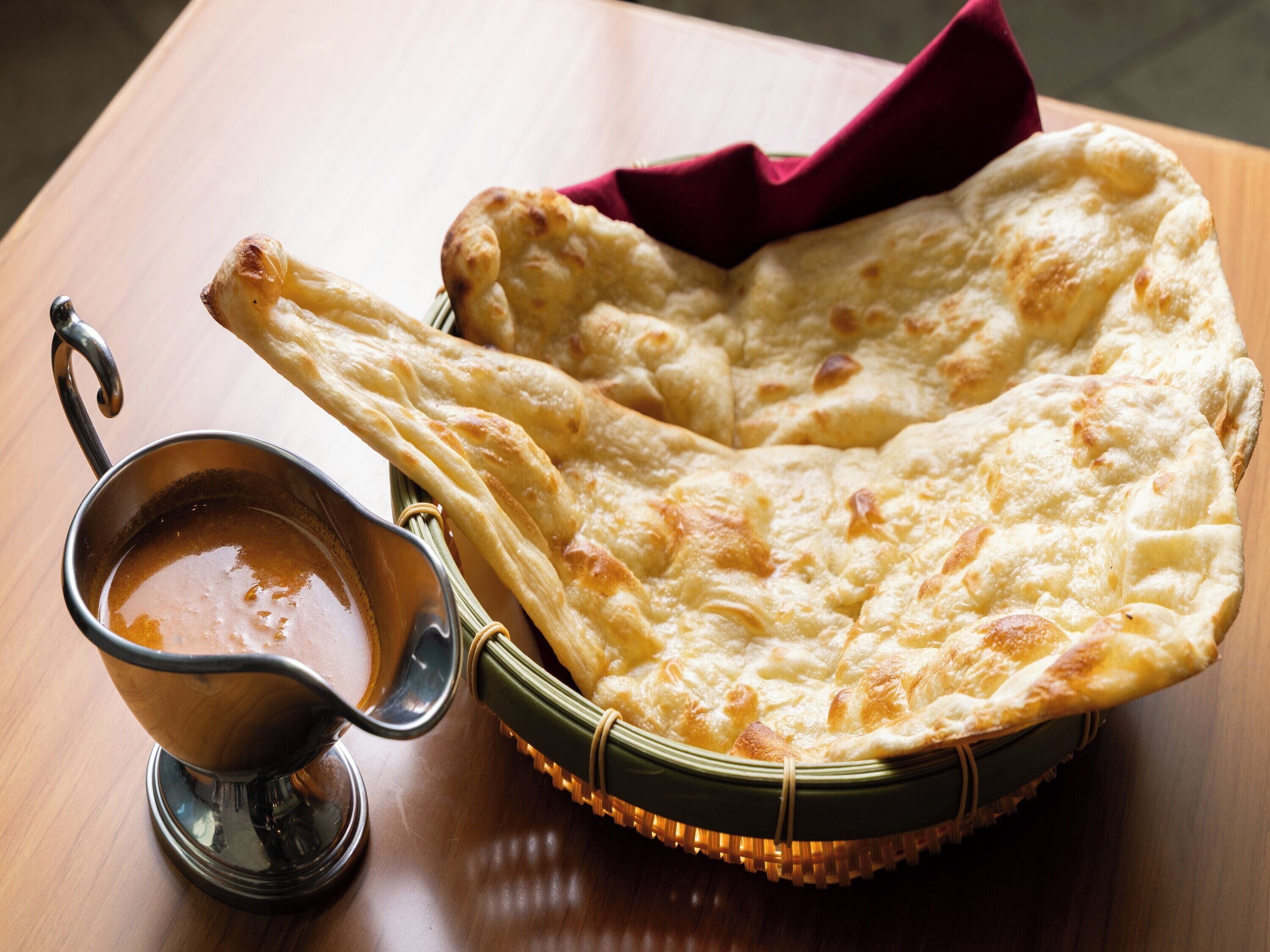 Un pan plano tradicional con salsa para mojar sobre una mesa de madera.