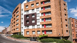 A multi-story hotel with a brick facade, multiple windows, and a prominent sign on the front. - Viaggio Urbano (Bogotá)