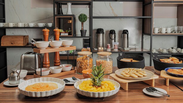 Disposição de buffet com diversos alimentos e utensílios de servir.
