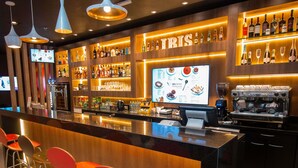 Un espace bar avec un présentoir pour afficher le menu, des tabourets de bar et une machine à café.