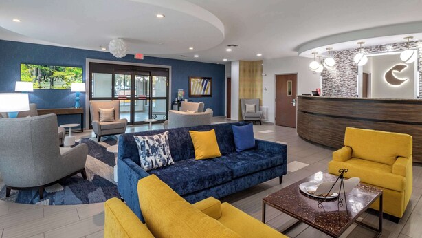 A modern lobby with a reception desk, seating area, and a large window. - Comfort Suites Natchitoches (Natchitoches)