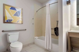 Un baño con inodoro, ducha con puerta de cristal y un perchero para toallas.