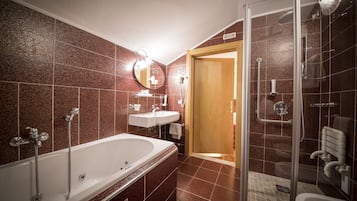 Un baño moderno con una bañera grande, ducha e inodoro.