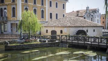 A historic building with a tiled roof and a small water feature in front.