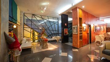 Un lobby moderno con pared de vidrio, un árbol de Navidad y una zona de estar.