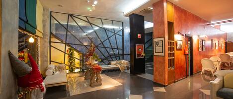 Un lobby moderno con pared de vidrio, un árbol de Navidad y una zona de estar.