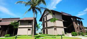 A modern hotel with multiple-story buildings, a well-maintained lawn, and a palm tree. - Langkawi Lagoon Resort (Langkawi)
