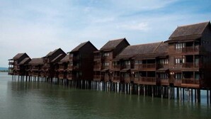A row of wooden overwater bungalows with balconies, connected by a walkway. - Langkawi Lagoon Resort (Langkawi)