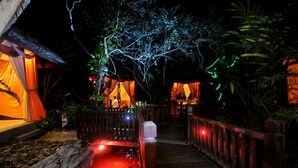 A wooden pathway leading to a building with a thatched roof and draped fabric. - Langkawi Lagoon Resort (Langkawi)