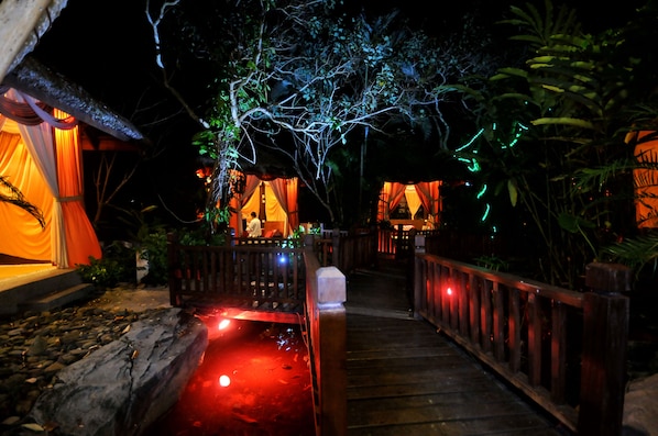 A wooden pathway leading to a building with a thatched roof and draped fabric. - Langkawi Lagoon Resort (Langkawi)