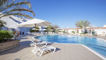 Een buitenzwembad, parasols voor strand/zwembad