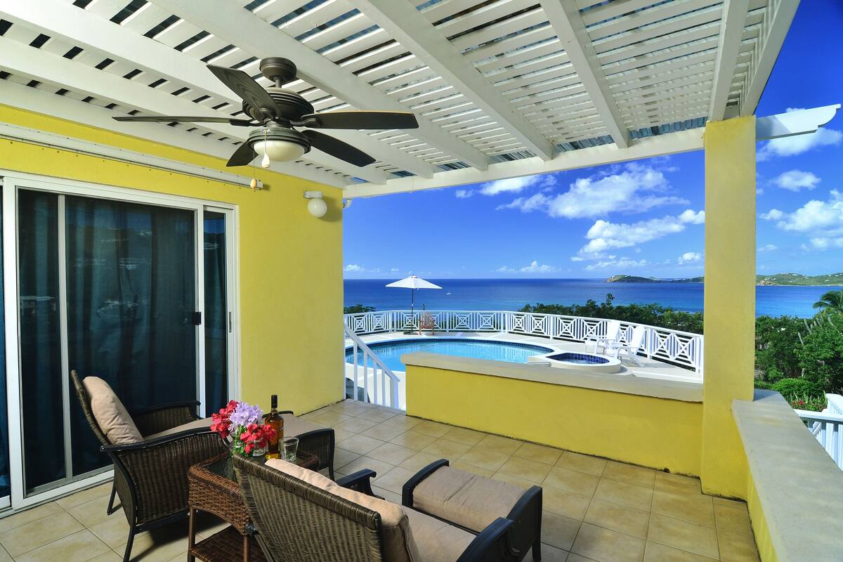 A balcony with a pool, chairs, and a ceiling fan.