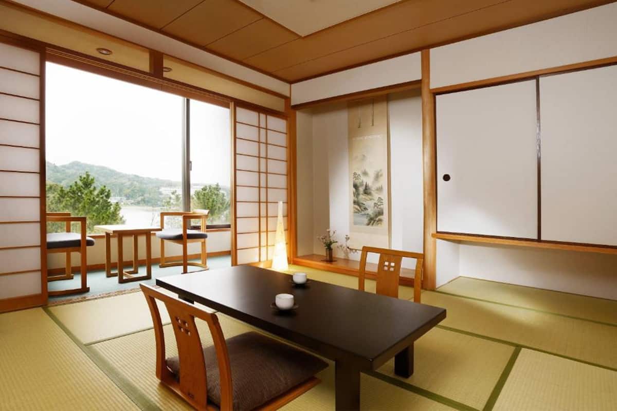 A traditional Japanese room with tatami flooring, a low table, and sliding doors.