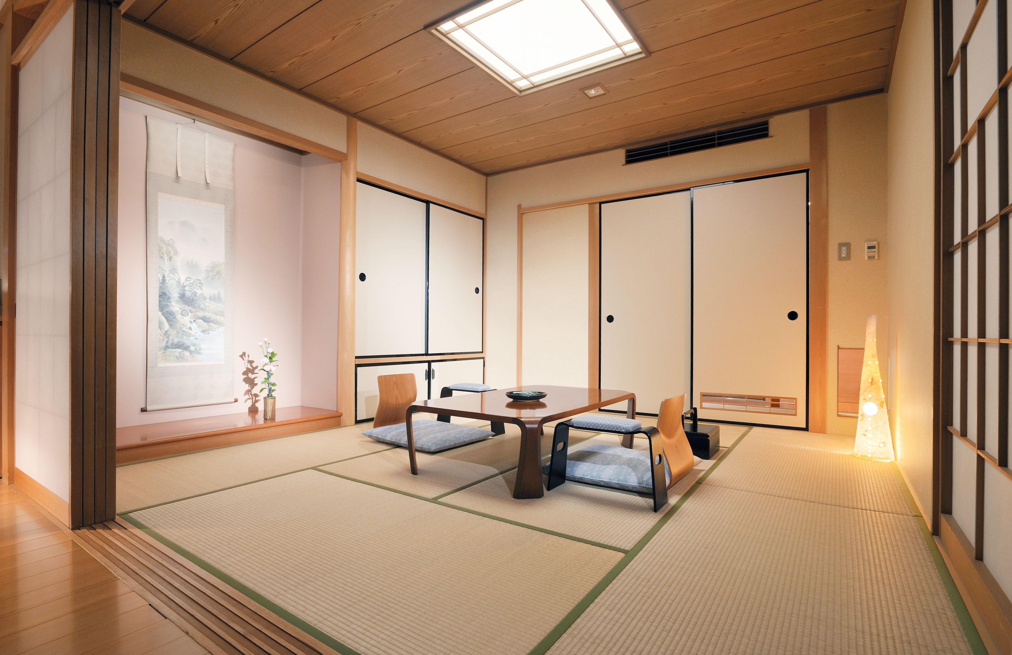 Perinteinen japanilainen huone, jossa on tatamimatto, matala pöytä ja liukuvat ovet.