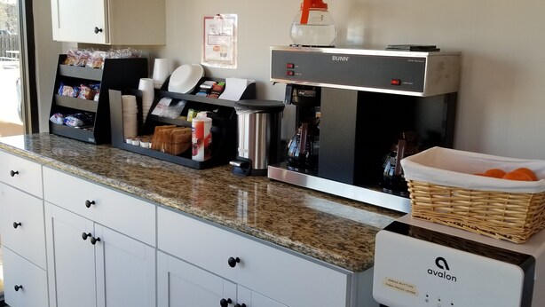 A kitchenette with a coffee machine, a water dispenser, and a snack bar.
