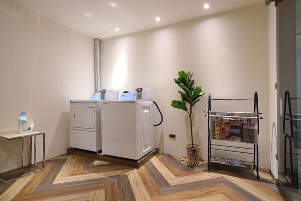 A modern laundry area with a washing machine, a dryer, and a drying rack.