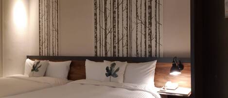 A hotel room with a large bed, a nightstand with a lamp, and a wall with vertical lines.