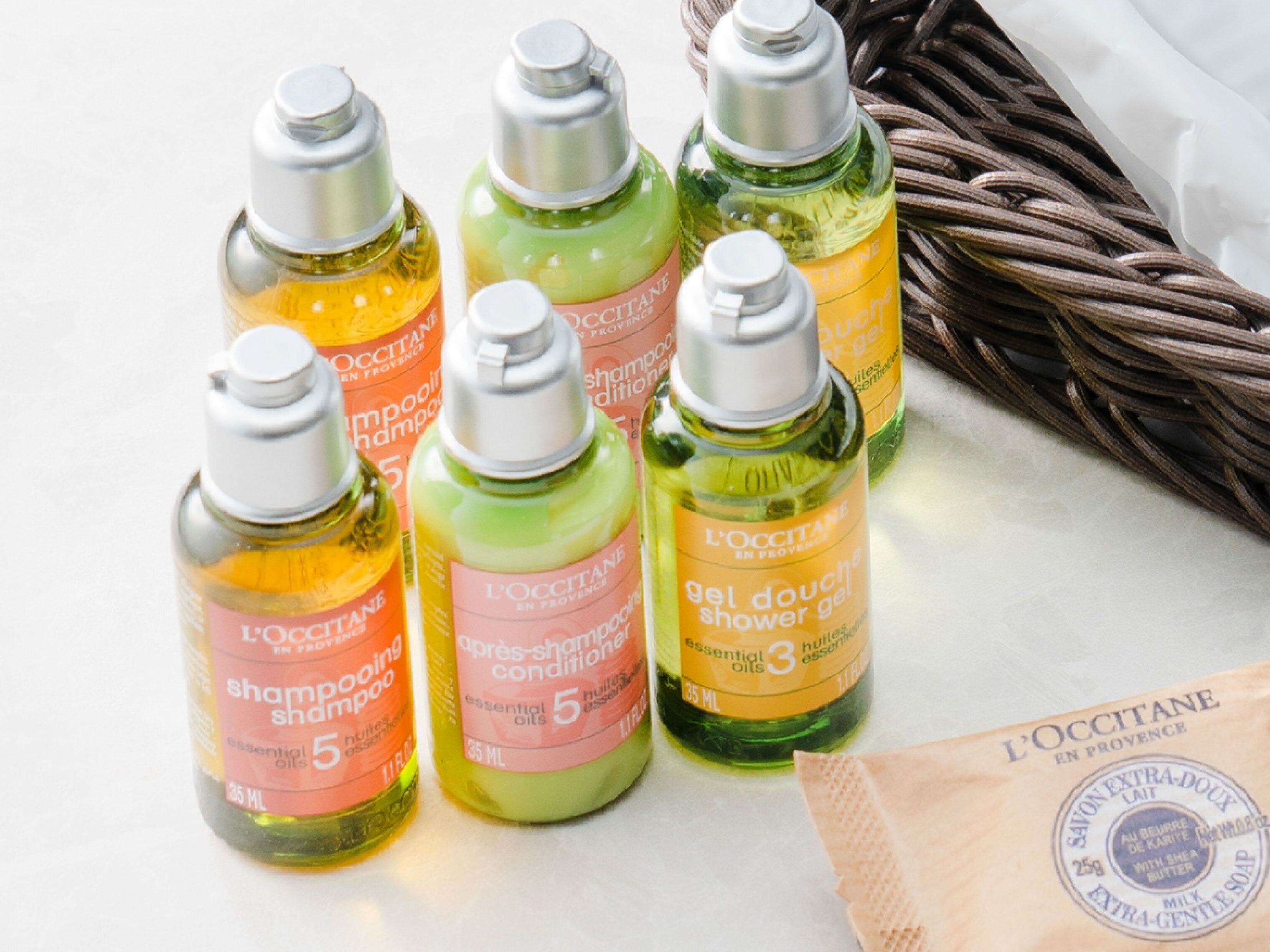 Six bottles of L'OCCITANE hair care products on a table.