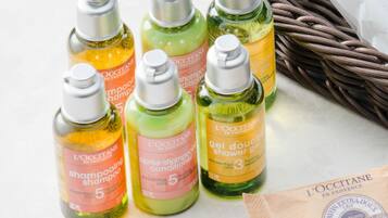 Six bottles of L'OCCITANE hair care products on a table.