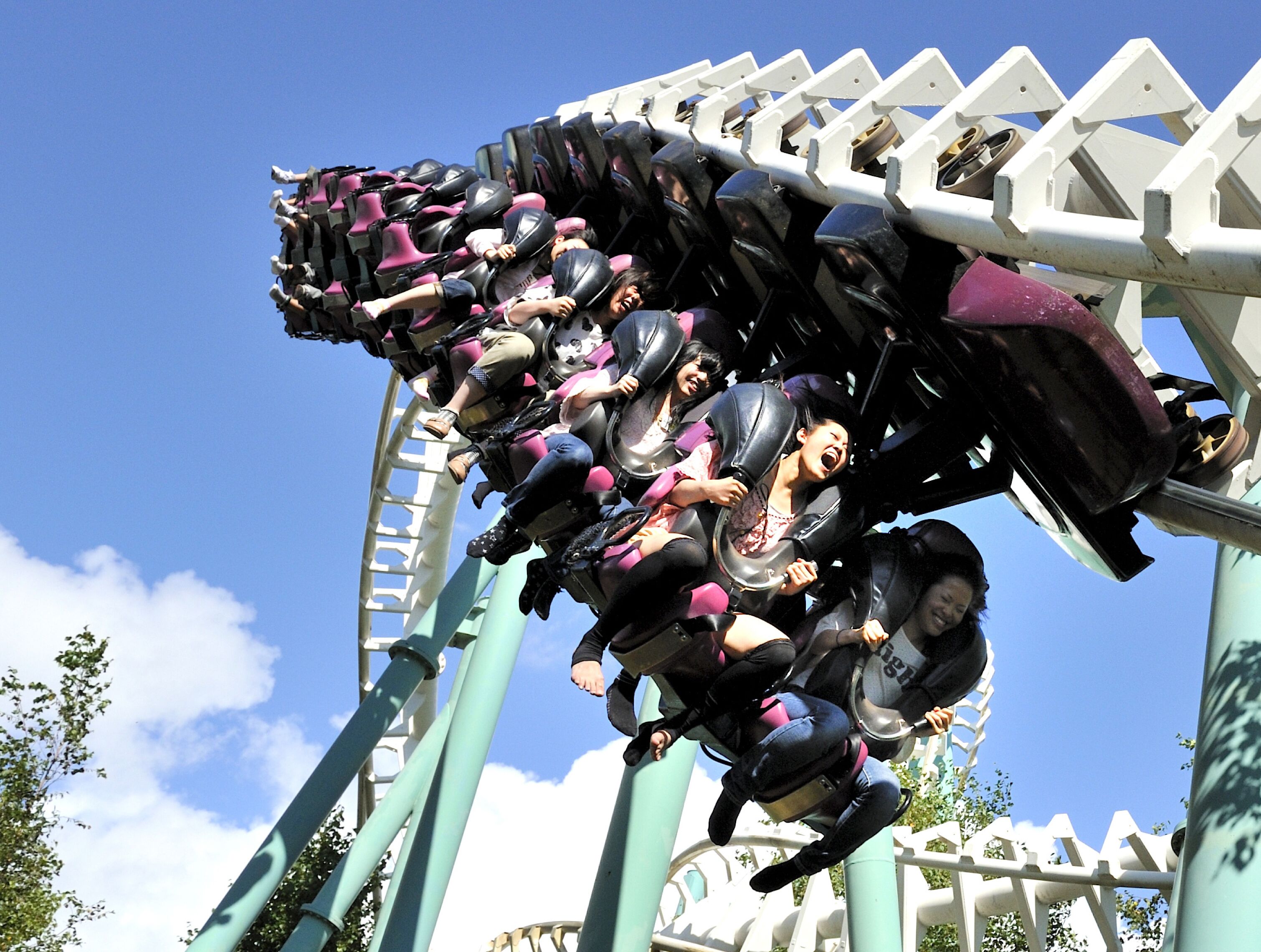 A roller coaster in motion with passengers seated in rows.