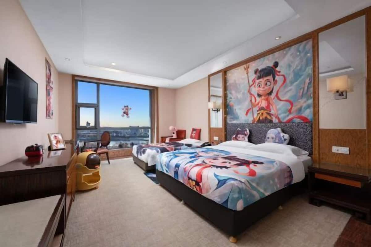 Een moderne hotelkamer met een groot bed, een bureau en een televisie.