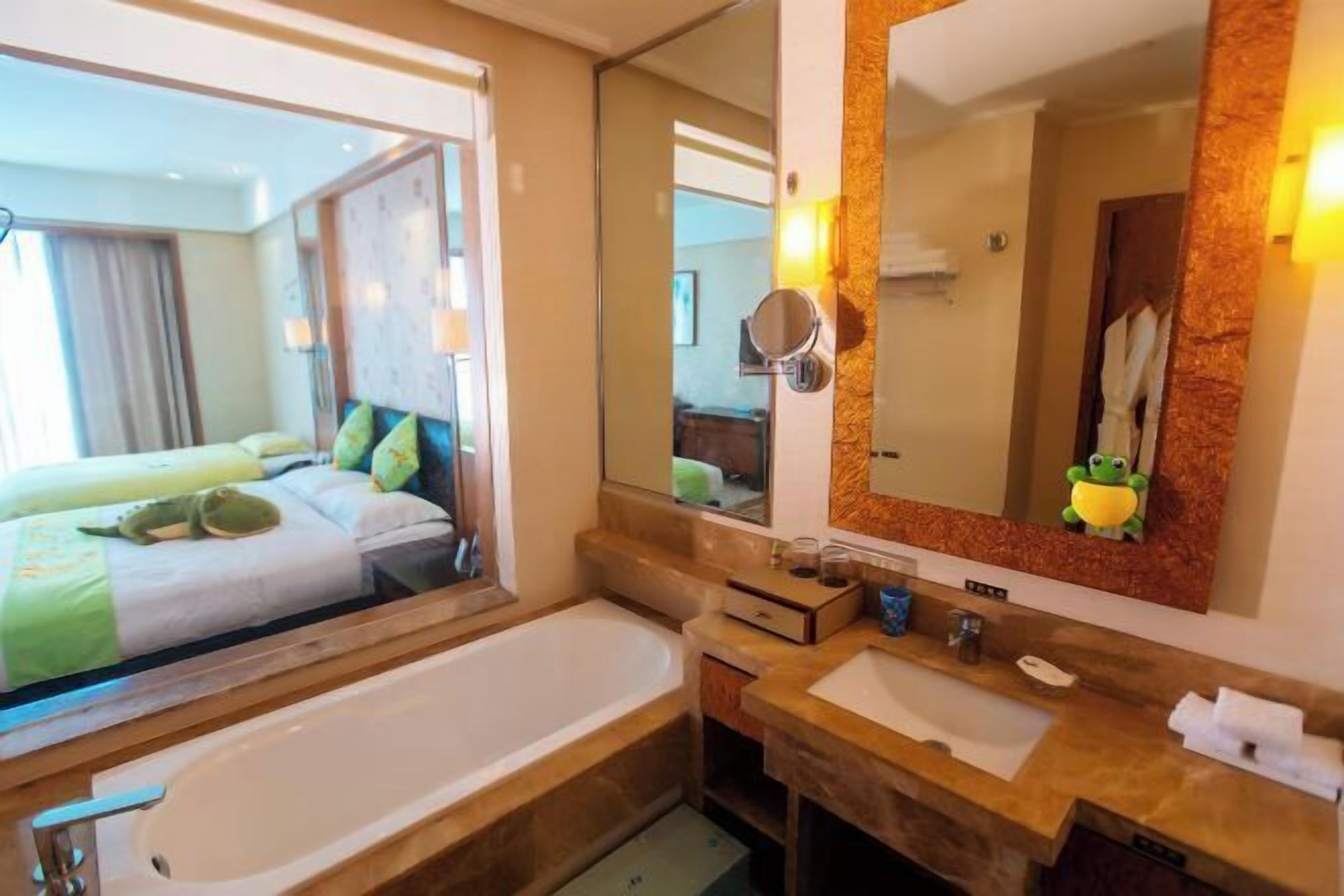 Un baño de hotel con bañera, lavamanos y espejo.