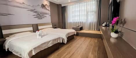 Habitación de hotel con dos camas, un cuadro grande en la pared, un televisor y una mesita con una planta.