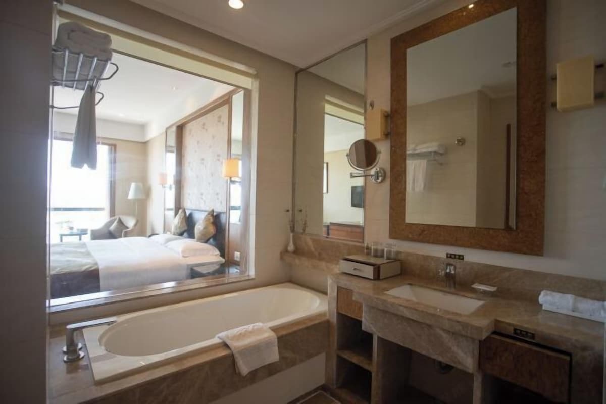 Une salle de bain moderne avec une grande baignoire, un meuble-lavabo et un grand miroir.