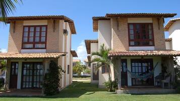 A row of two-story houses with tiled roofs, a small front porch, and a well-maintained lawn.