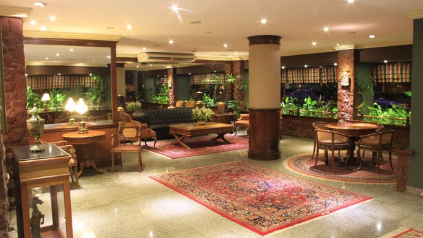 A spacious lobby with a large rug, seating area, and indoor plants. - Nobile Hotel Premier Hill (Asunción)