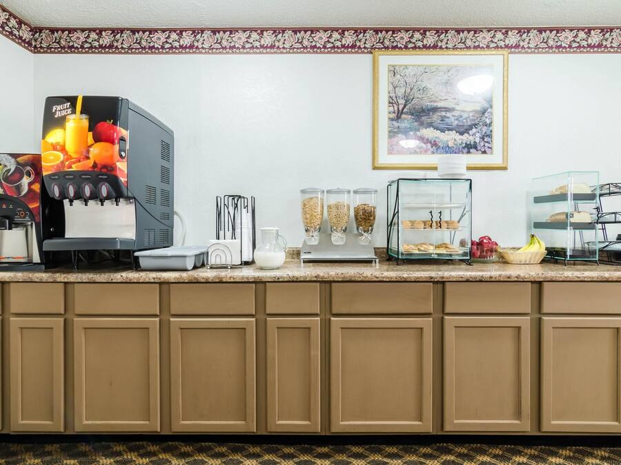 A kitchen counter with a fruit juice dispenser, a coffee maker, a glass carafe, a toaster, a glass jar with sugar, a glass jar with creamer, a glass jar with coffee, a glass jar with tea, a glass jar with milk, a glass jar with yogurt, a glass jar with butter, a glass jar with jam, a glass jar with honey, a glass jar with peanut butter, a glass jar with jam, a glass jar with honey, a glass jar with peanut butter, a glass jar with jam, a glass jar with honey, a glass jar with peanut butter, a glass jar with jam, a glass jar with honey, a glass jar with peanut butter, a glass jar with jam, a glass jar with honey, a glass jar with peanut butter, a glass jar with jam, a glass jar with honey, a glass jar with peanut butter, a glass jar with jam, a glass jar with honey, a glass jar with peanut butter,