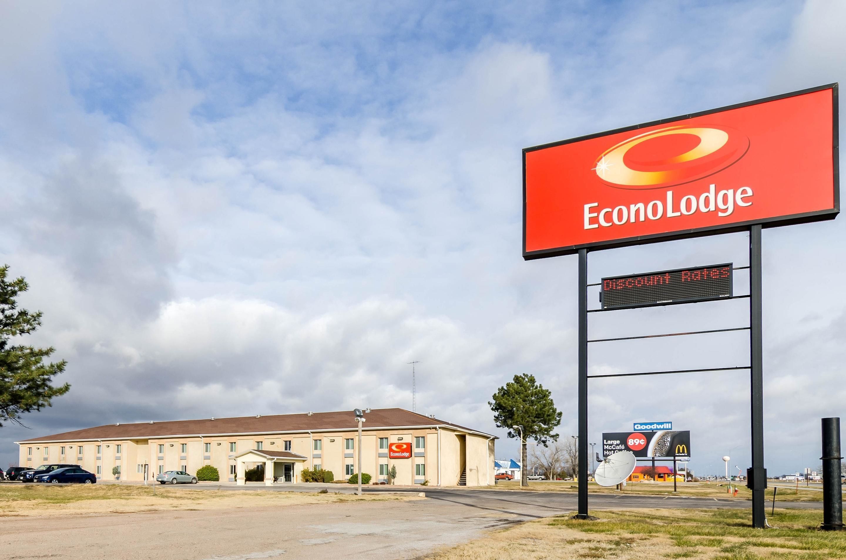 A hotel named EconoLodge with a large sign, a parking lot, and a building with multiple windows.
