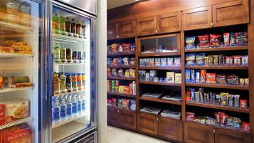 A refrigerated section with various food items and a shelf stocked with snacks and beverages.