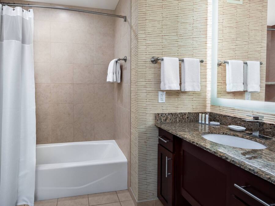 A modern bathroom with a bathtub, a sink, and a mirror.