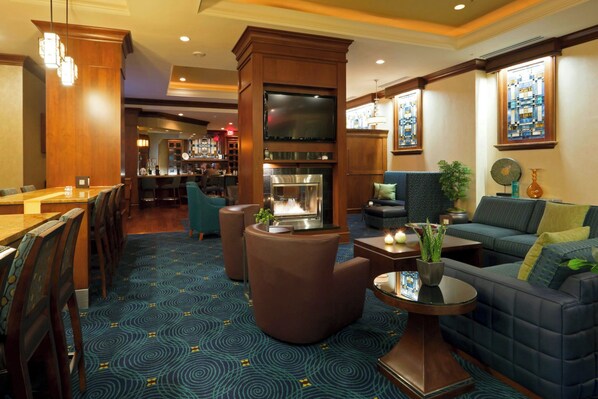 A hotel lobby with a bar area, seating arrangements, and a fireplace. - Residence Inn by Marriott Cincinnati Downtown/The Phelps (Cincinnati)