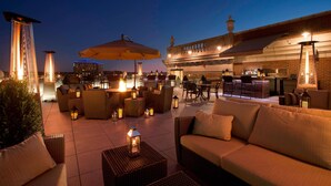 An outdoor patio area with wicker furniture, lanterns, and a bar area. - Residence Inn by Marriott Cincinnati Downtown/The Phelps (Cincinnati)