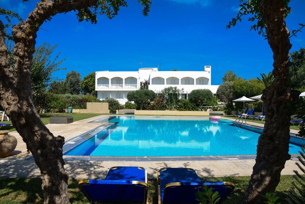 Alberca al aire libre, sombrillas en la alberca y camastros 