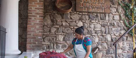 Eine Frau steht an einem Empfangstresen, über dem ein Schild mit der Aufschrift 'Hotel Dosada de Don Rodrigo la Antigua' hängt.