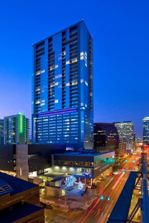 A high-rise hotel with multiple floors, a modern architectural design, and a well-lit facade.