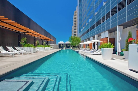 Una piscina al aire libre, camas de piscina con cargo, sombrillas