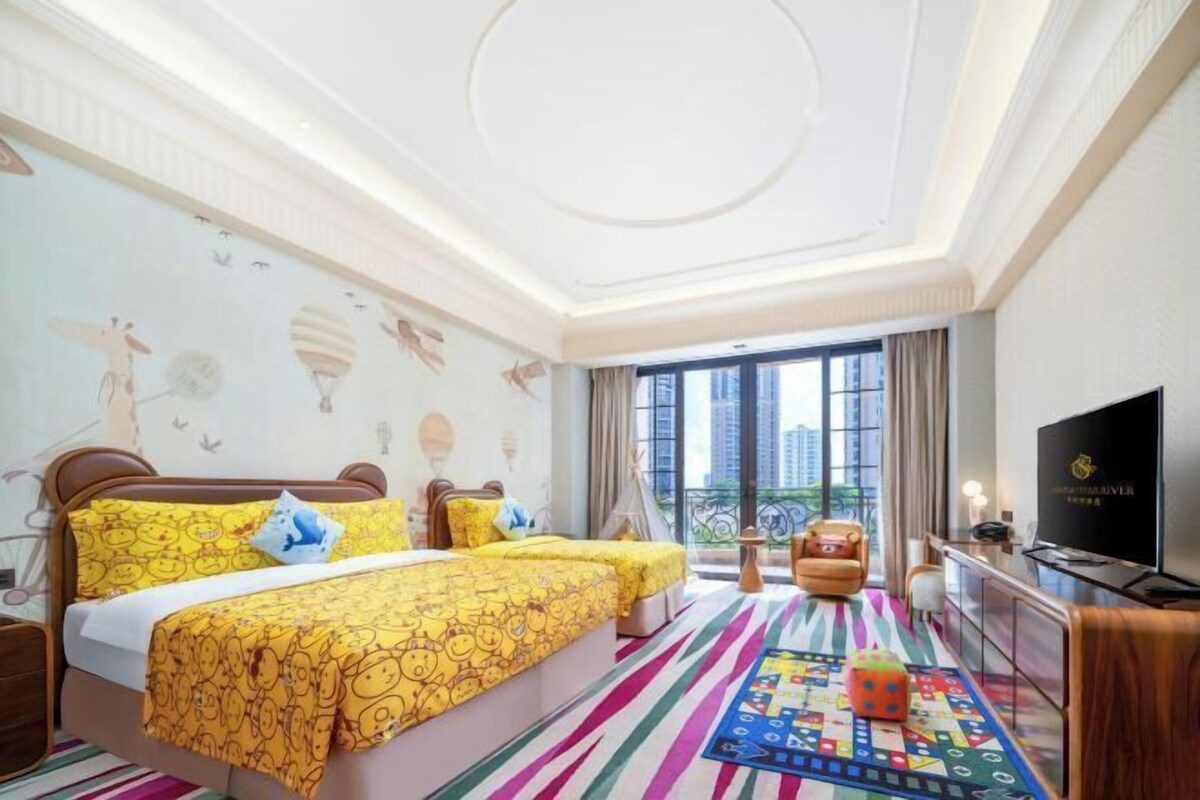 Une chambre d’hôtel avec deux lits, une télévision, un balcon avec vue et un tapis aux couleurs vives.
