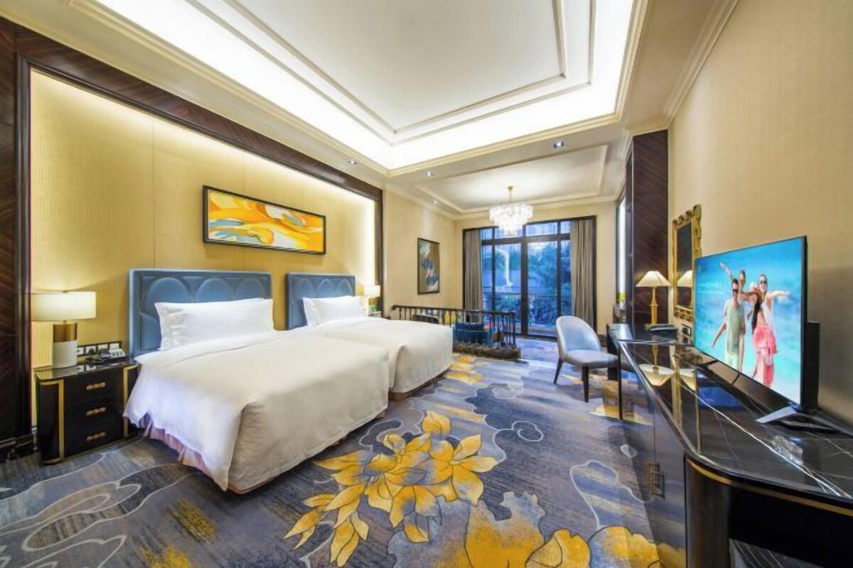 Une chambre d’hôtel avec un grand lit, un bureau, une télévision et une vue sur l’extérieur.