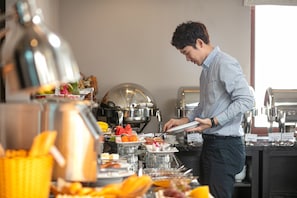 A buffet setup with various food items and kitchen equipment. - Imperial Hotel & Spa (Hanoi)