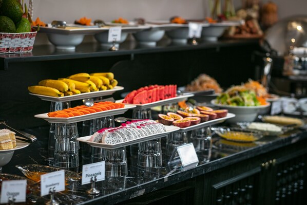 A buffet with various food items including bananas, watermelon, and a variety of desserts. - Imperial Hotel & Spa (Hanoi)