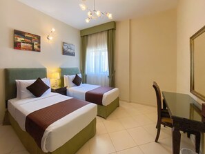 A hotel room with two beds, a desk, and a chair. - Auris Boutique Hotel Apartments (Dubai)