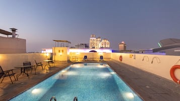 Una piscina al aire libre, sombrillas, tumbonas