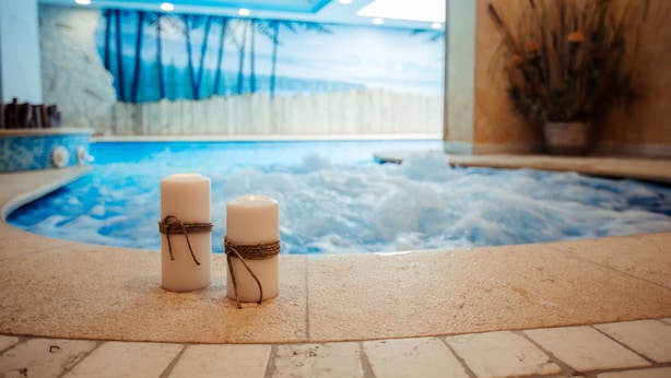A spa area with a hot tub and two candles tied with a string. - Albergo Dimaro Wellness & Family Hotel (Dimaro Folgarida)
