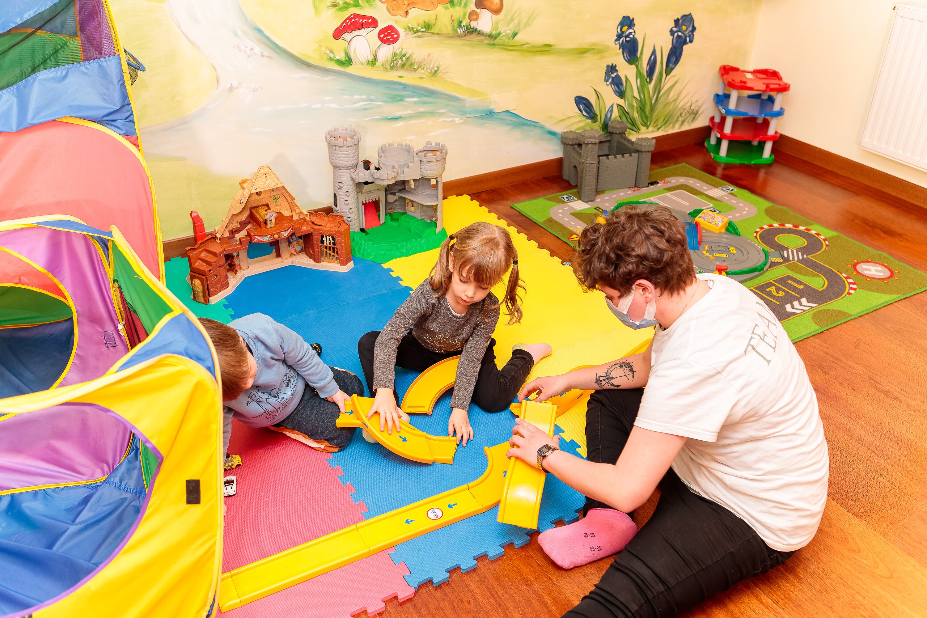 A play area with a castle, a slide, and a tent.