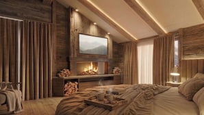 A cozy room with a fireplace, a bed, a TV mounted on the wall, and a wooden ceiling. - Albergo Dimaro Wellness & Family Hotel (Dimaro Folgarida)
